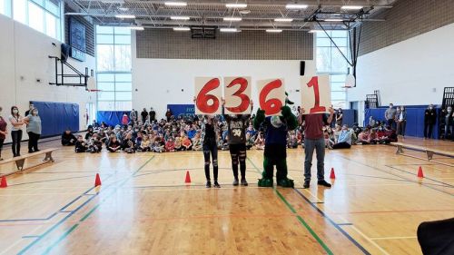 Granite Ridge Students unveil their total for donations raised for the North Frontenac Food Bank during the Slime Challenge against North Addington Education Centre.
